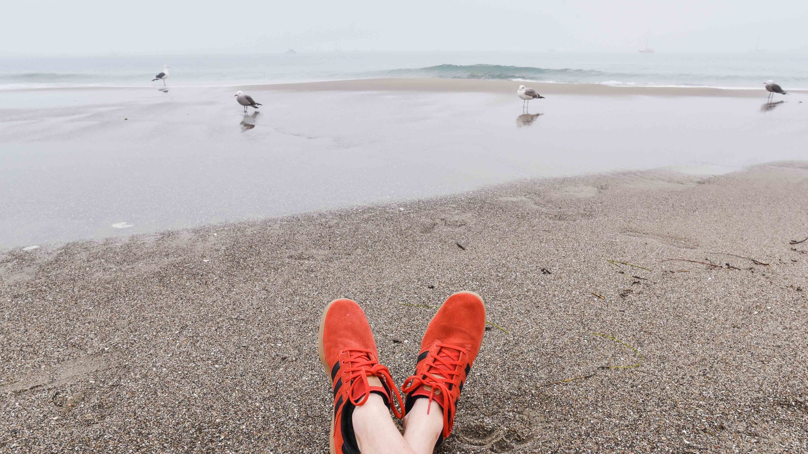 red sneakers in sand long weekend