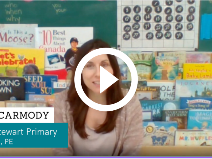 A screenshot of a teacher in front of books in a video
